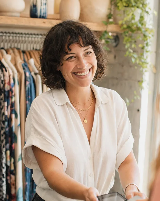 A shop owner ringing up a customer at her boutique counter