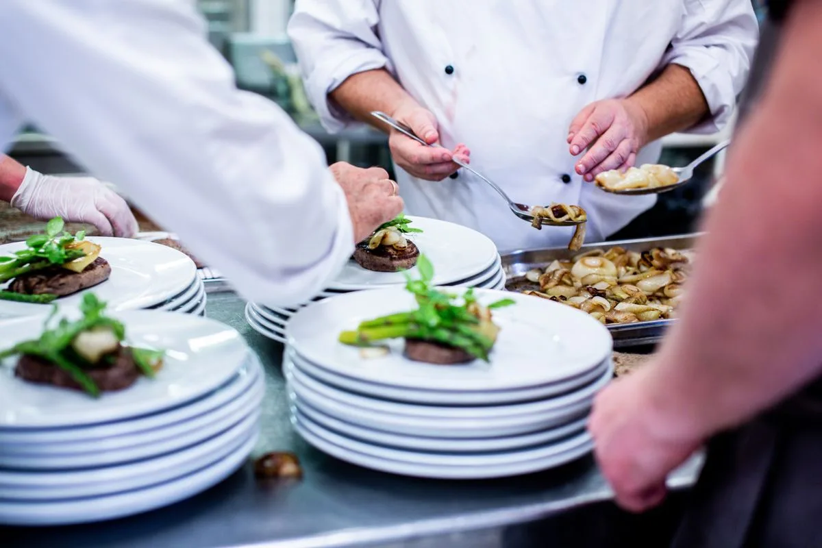 Chefs plating dishes in a professional kitchen