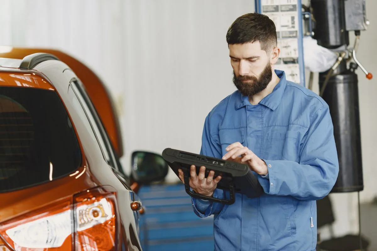 Mechanic using a diagnostic tool in a service garage