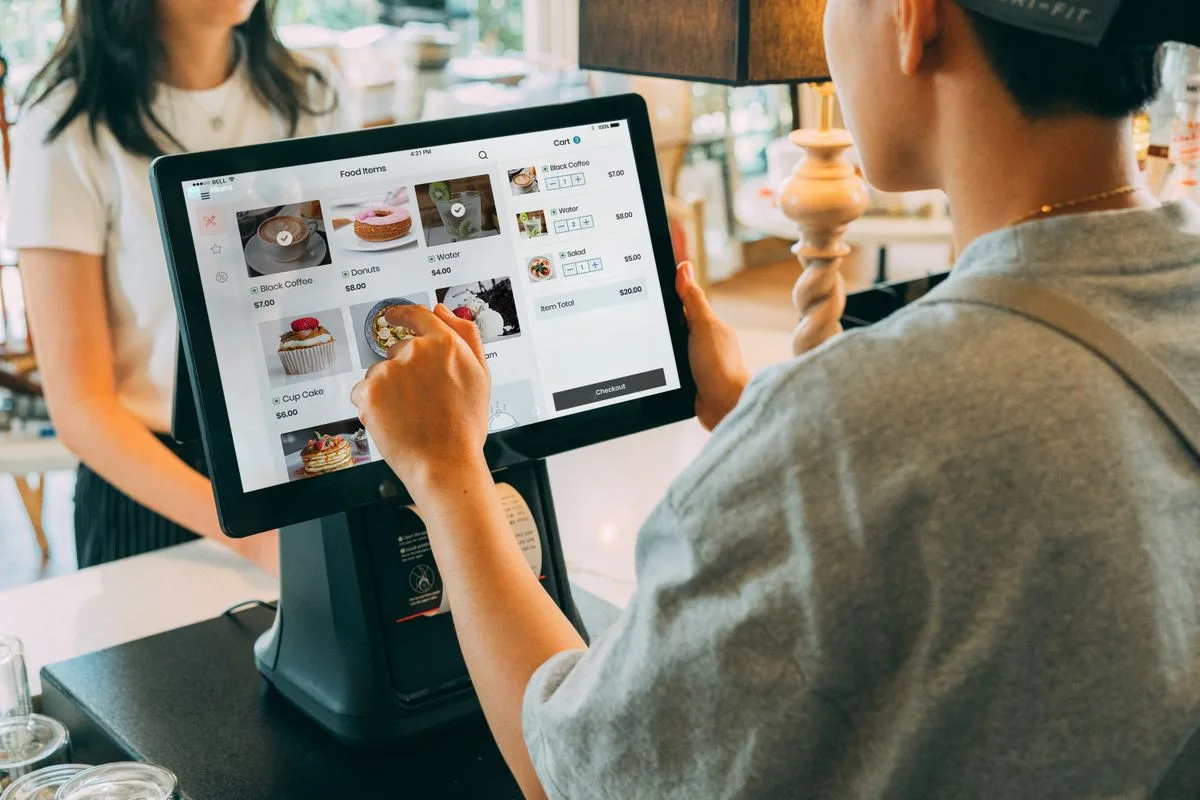 Cashier ringing up an order on a point of sale screen